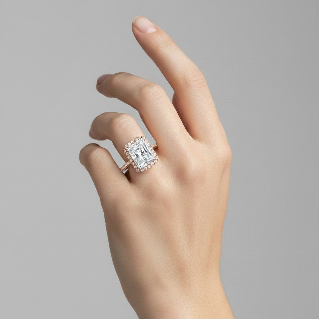 My Store 4 18K solid gold halo pavé lab diamond ring worn on a woman's finger, featuring a radiant cut center stone.