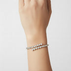 My Store 4 bypass open bangle bracelet featuring alternating pear and heart cut diamonds on a woman's wrist.