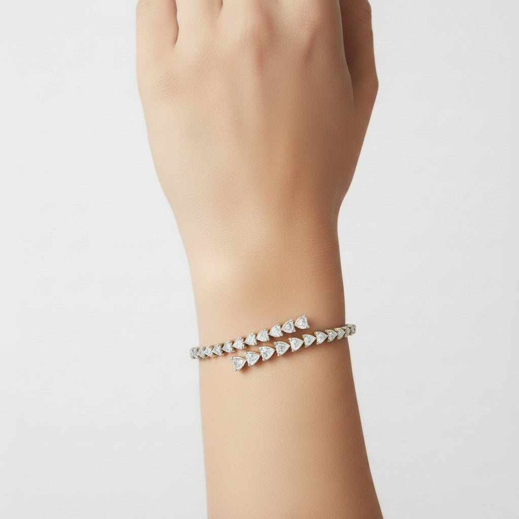 My Store 4 bypass open bangle bracelet featuring alternating pear and heart cut diamonds on a woman's wrist.