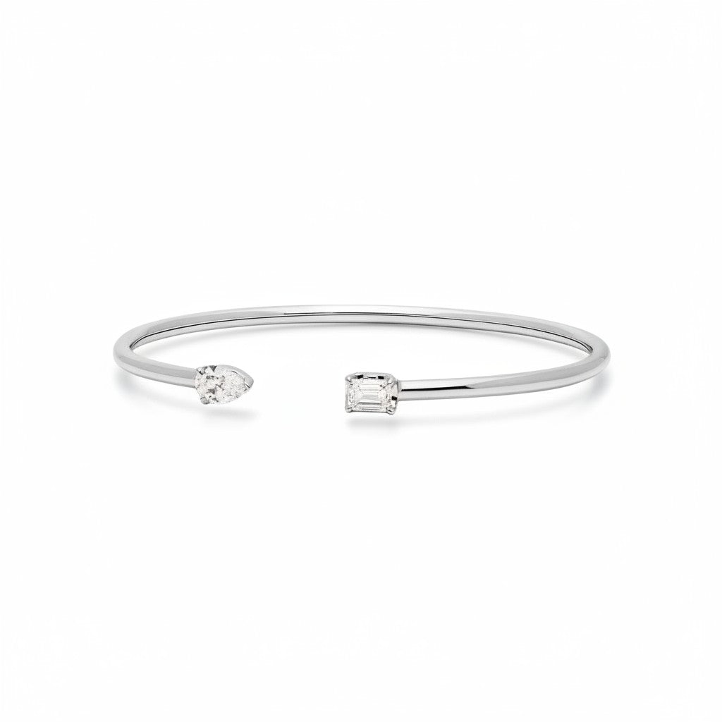 My Store 4 open cuff bracelet in white gold featuring an asymmetrical pear-cut and emerald-cut diamond solitaire.