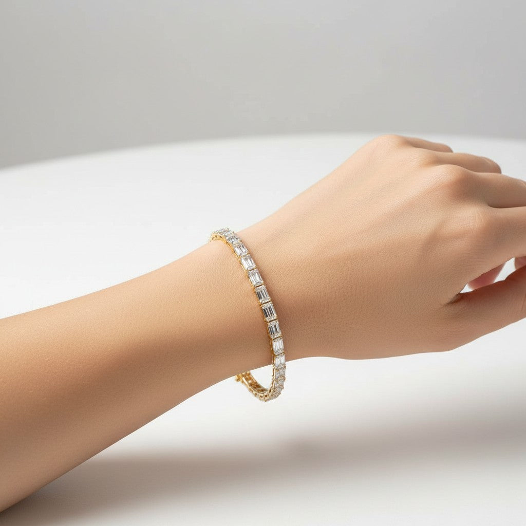 My Store 4 modern east-west emerald cut diamond bracelet in yellow gold worn on a wrist against a white background