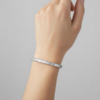My Store 4 custom emerald cut diamond tennis bracelet in white gold worn on a woman's wrist.