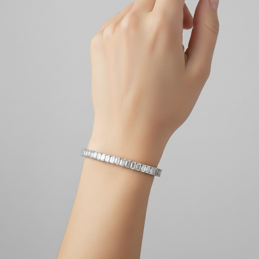 My Store 4 custom emerald cut diamond tennis bracelet in white gold worn on a woman's wrist.