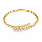 My Store 4 gold open bangle bracelet featuring alternating pear and heart cut diamonds in a bypass silhouette.