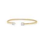 My Store 4 open cuff bracelet in yellow gold featuring an asymmetrical pear-cut and emerald-cut diamond setting.