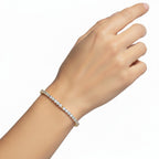 My Store 4 round diamond tennis bracelet in yellow gold with a four-prong setting worn on a woman's wrist.