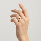 My Store 4 solid gold flat band wedding ring with an offset row of micro-pavé diamonds worn on a woman's finger.