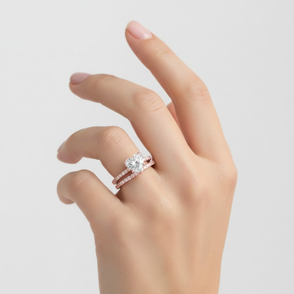 My Store 4 heart-cut diamond engagement ring and matching pavé wedding band set in rose gold worn on a woman's finger.