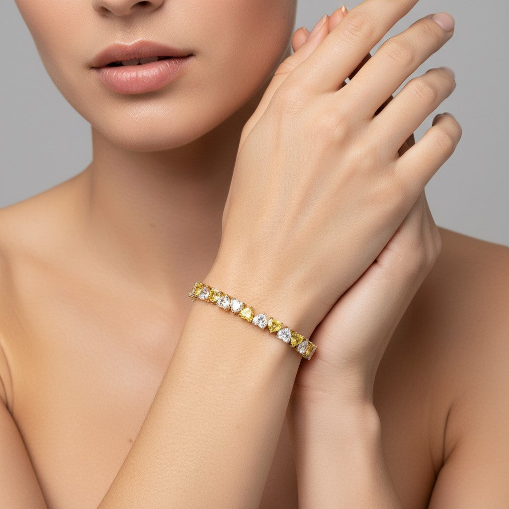 My Store 4 two-tone tennis bracelet featuring alternating fancy yellow and white heart-cut diamonds on a model's wrist.