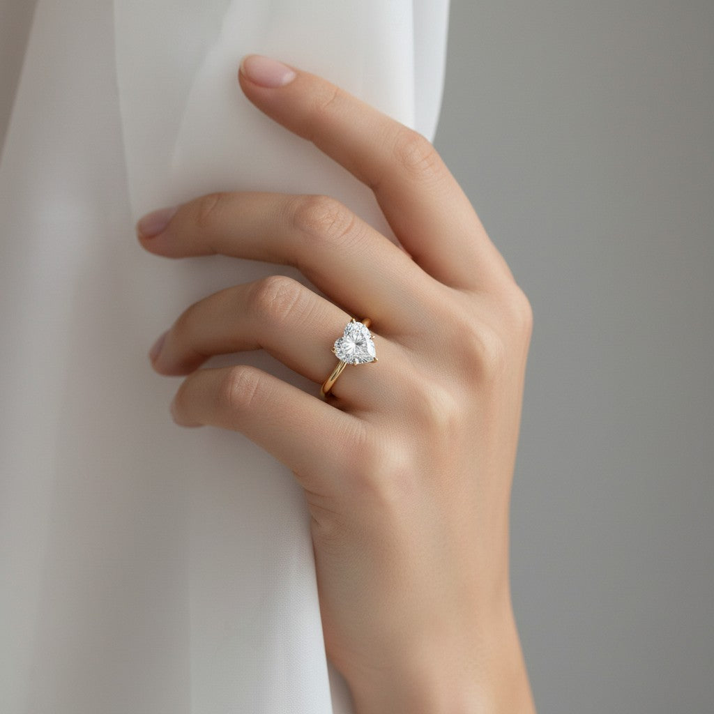 My Store 4 18K solid gold solitaire heart-shaped diamond ring worn on a woman's hand against a soft white fabric