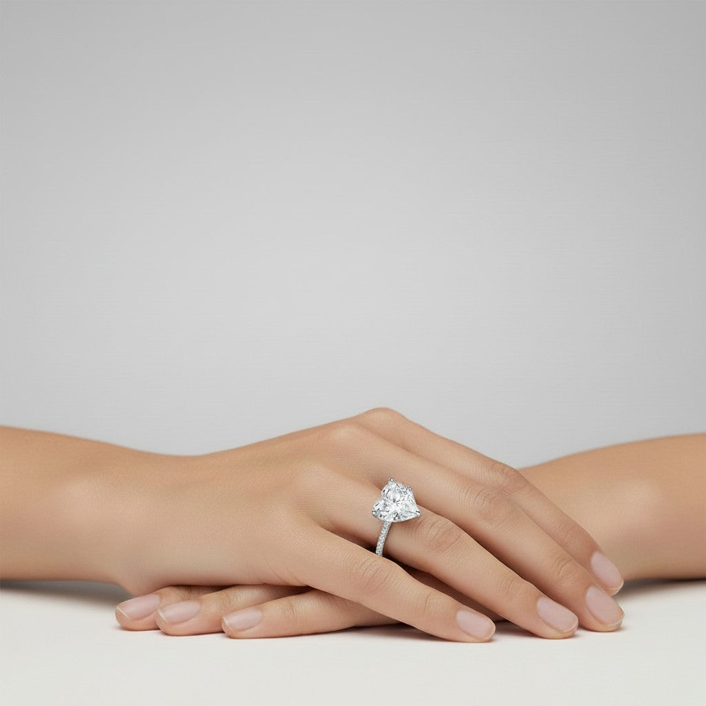 My Store 4 18K solid gold solitaire ring with a heart-shaped lab-grown diamond and pavé band on a woman's hand.