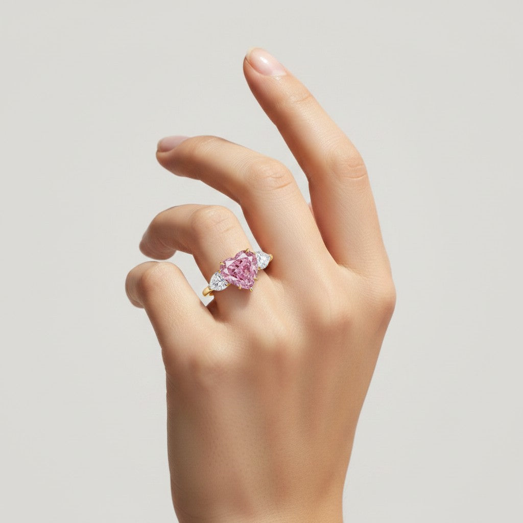 My Store 4 18K solid gold trilogy ring featuring a heart-cut pink lab-grown diamond and two side accent diamonds.