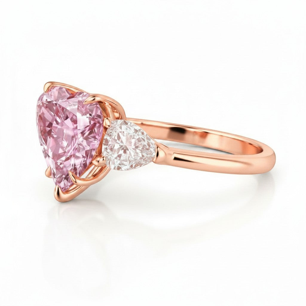My Store 4 18K rose gold trilogy ring featuring a heart-cut fancy pink lab-grown diamond and pear-cut side stones.