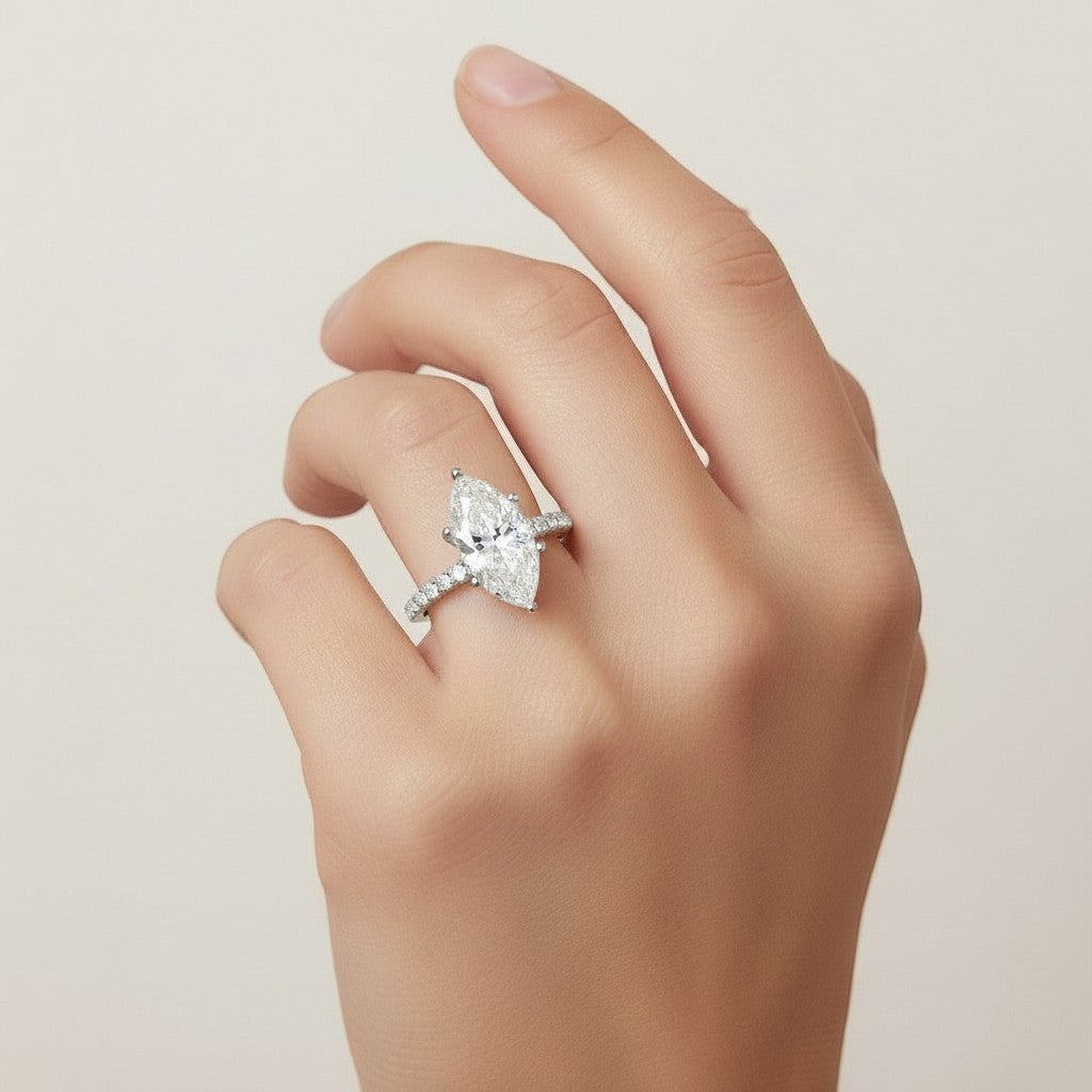 My Store 4 18K solid gold marquise cut solitaire engagement ring with pavé diamond band worn on a woman's finger