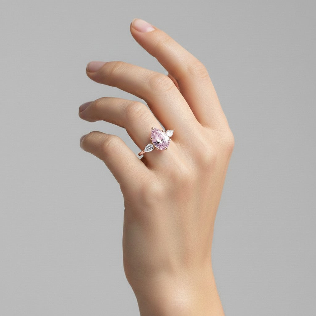 My Store 4 18K solid gold ring featuring an oval fancy pink diamond with heart-cut side diamonds on a woman's hand.
