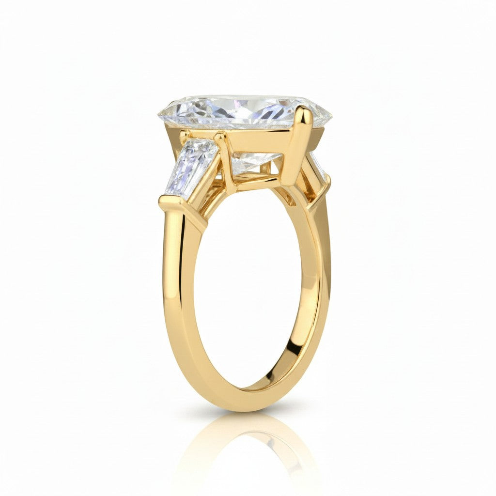 My Store 4 three-stone engagement ring with a pear-cut center diamond and tapered baguette side stones in yellow gold.