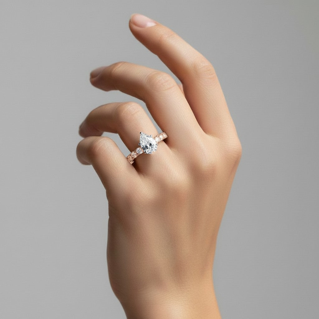 My Store 4 pear cut diamond engagement ring with shared-prong accent band on a hand in 18K yellow gold