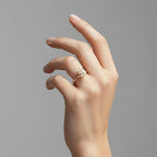 My Store 4 pear cut diamond engagement ring with hidden halo and pavé bridge on a yellow gold band worn on a hand