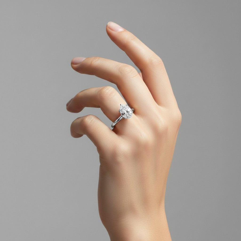 My Store 4 pear cut solitaire engagement ring with hidden halo and pavé bridge on a model's hand