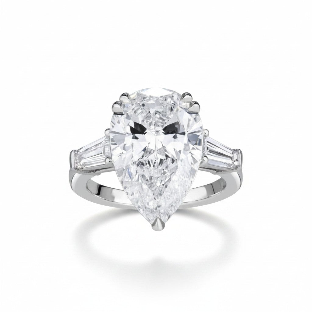 My Store 4 three-stone engagement ring with a pear-cut center diamond and tapered baguette side stones in white gold.