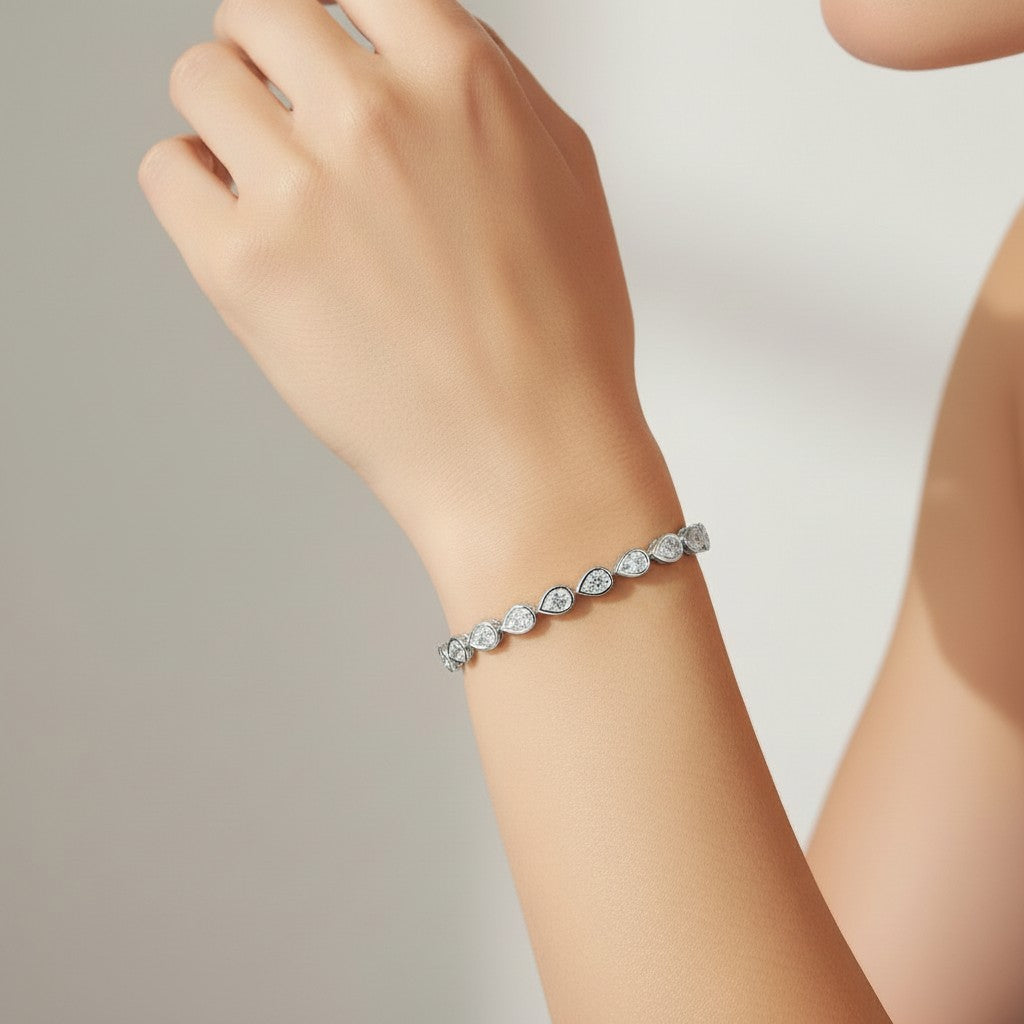 My Store 4 pear cut diamond tennis bracelet in a protective bezel setting worn on a woman's wrist.