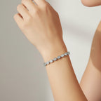 My Store 4 pear cut diamond tennis bracelet in a protective bezel setting worn on a woman's wrist.