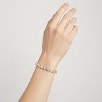 My Store 4 fancy-cut pear diamond tennis bracelet in yellow gold worn on a woman's wrist against a neutral background.