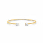 My Store 4 open cuff bracelet in yellow gold featuring an asymmetrical pear-cut and emerald-cut diamond solitaire.