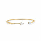 My Store 4 open cuff bracelet in yellow gold with a pear-cut diamond on one end and an emerald-cut diamond on the other.