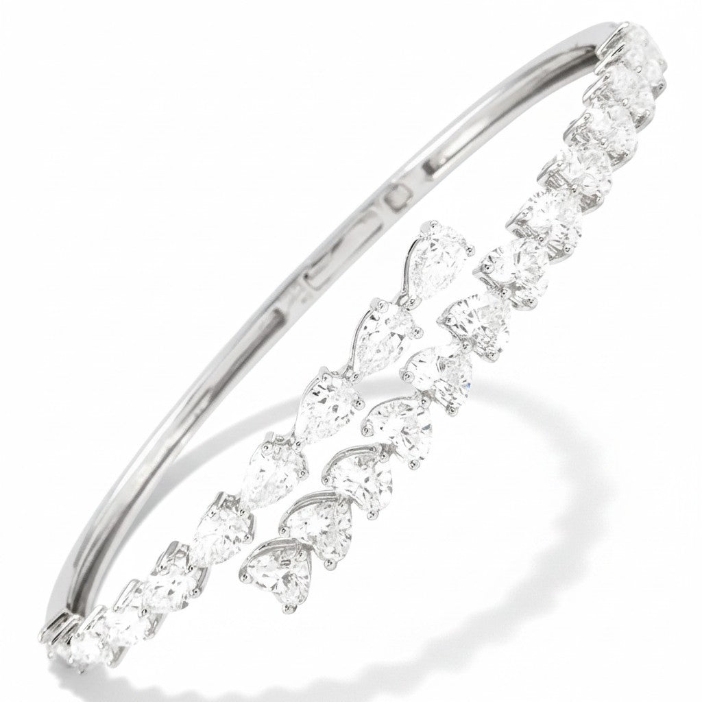 My Store 4 white gold open bangle bracelet featuring alternating pear-cut and heart-cut diamonds in a bypass design.
