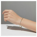 My Store 4 tennis bracelet featuring a central pear-cut diamond surrounded by round diamonds on a gold chain.