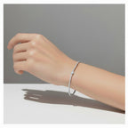 My Store 4 tennis bracelet featuring a delicate line of round diamonds and a pear-cut center stone on a wrist.