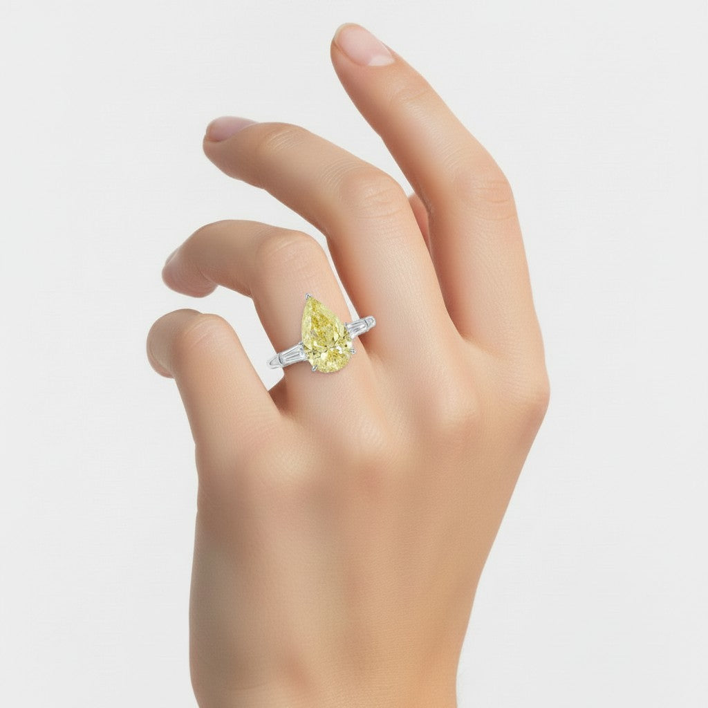 My Store 4 18K gold trilogy engagement ring featuring a pear-cut fancy yellow diamond and baguette side stones.