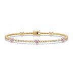 My Store 4 tennis bracelet in gold featuring round white diamonds and fancy pink heart-cut diamond stations.