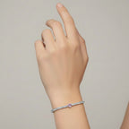 My Store 4 tennis bracelet featuring a central pink heart-cut diamond surrounded by round white diamonds on a wrist.