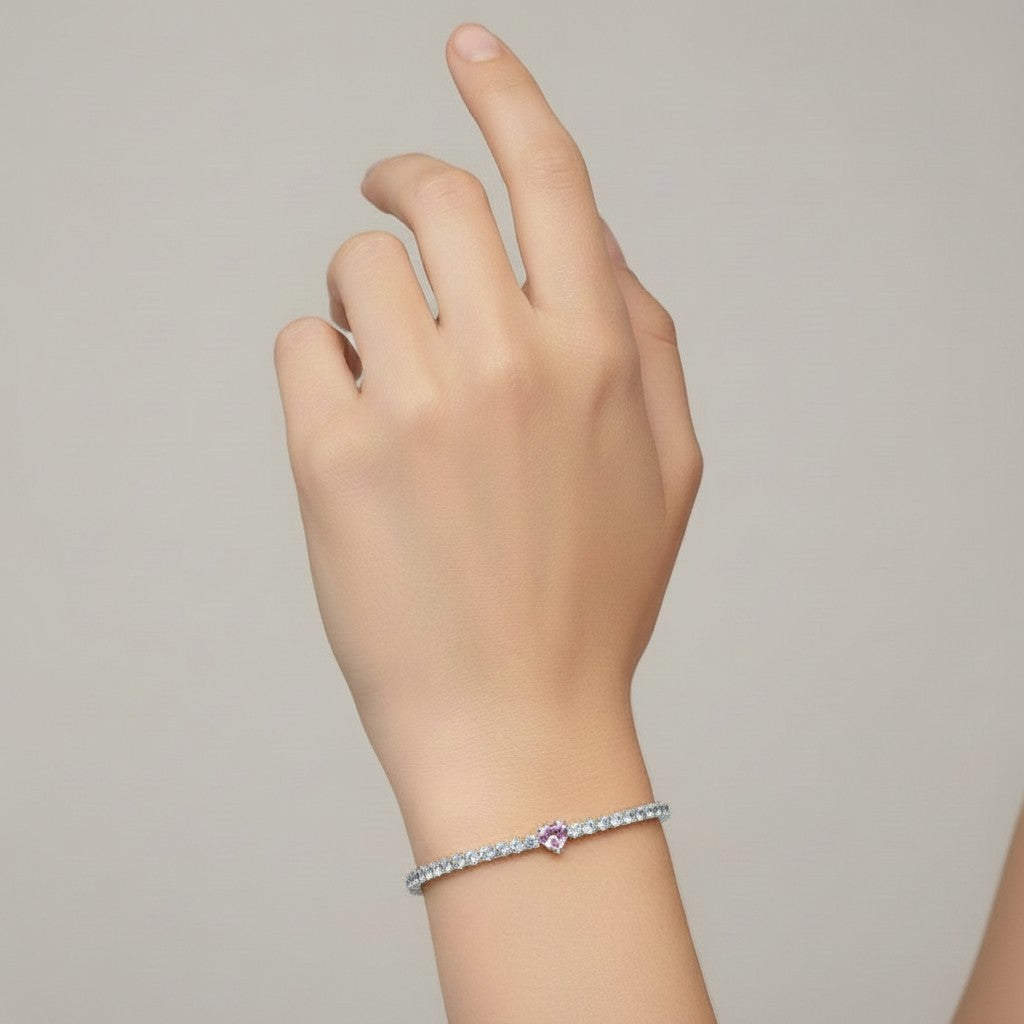 My Store 4 tennis bracelet featuring a central pink heart-cut diamond surrounded by round white diamonds on a wrist.