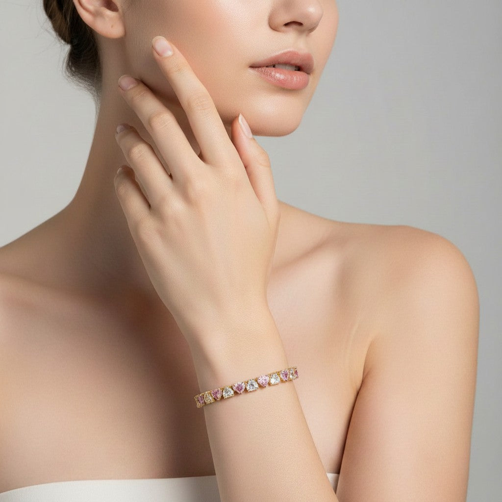 My Store 4 tennis bracelet featuring alternating pink and white heart-cut stones set in gold on a model's wrist.