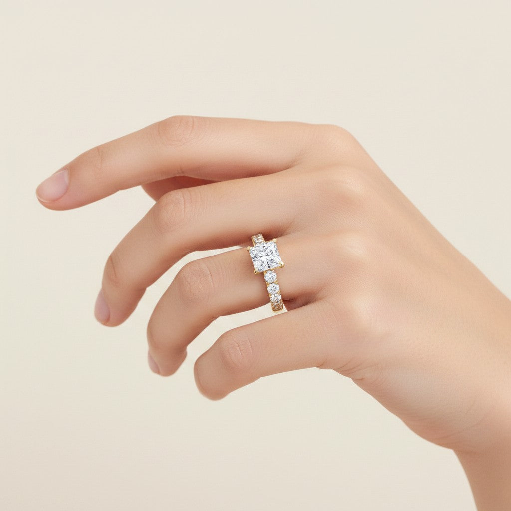 My Store 4 18K solid gold princess-cut lab diamond engagement ring set with a pavé band worn on a woman's finger.