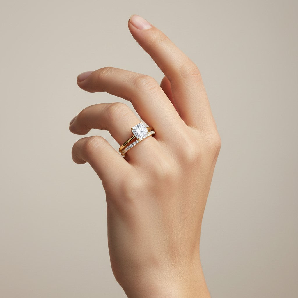 My Store 4 radiant cut solitaire engagement ring and micro-pavé eternity band set in 18K yellow gold on a hand.