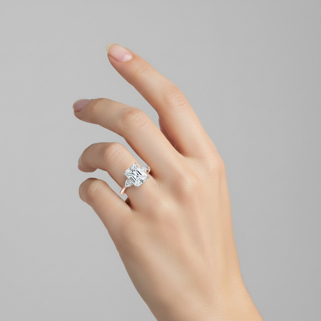 My Store 4 radiant cut three-stone engagement ring with trillion side diamonds on a woman's hand in yellow gold.