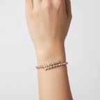 My Store 4 rose gold open bangle bracelet featuring alternating pear and heart cut diamonds on a woman's wrist