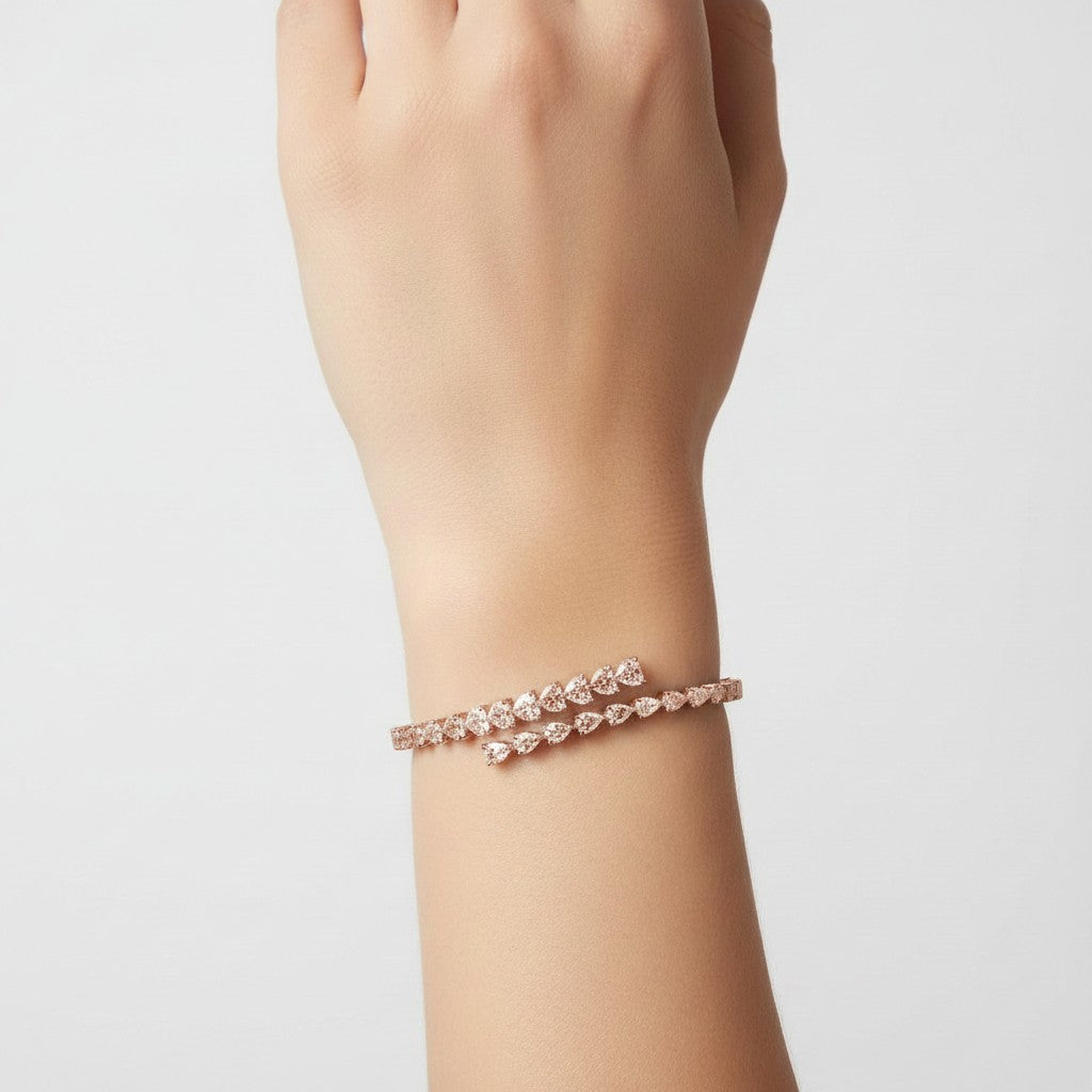 My Store 4 rose gold open bangle bracelet featuring alternating pear and heart cut diamonds on a woman's wrist