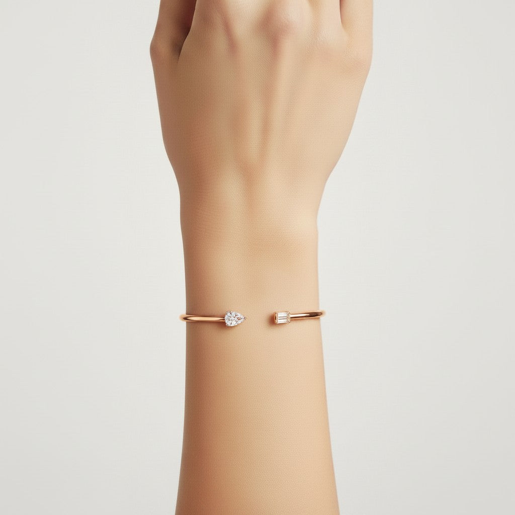 My Store 4 open cuff bracelet in rose gold featuring a pear-cut and emerald-cut diamond on a woman's wrist.