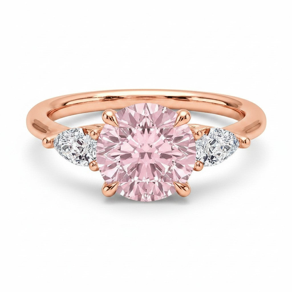 My Store 4 18K rose gold trilogy ring featuring a fancy pink pear-cut diamond centerpiece with side accent stones.