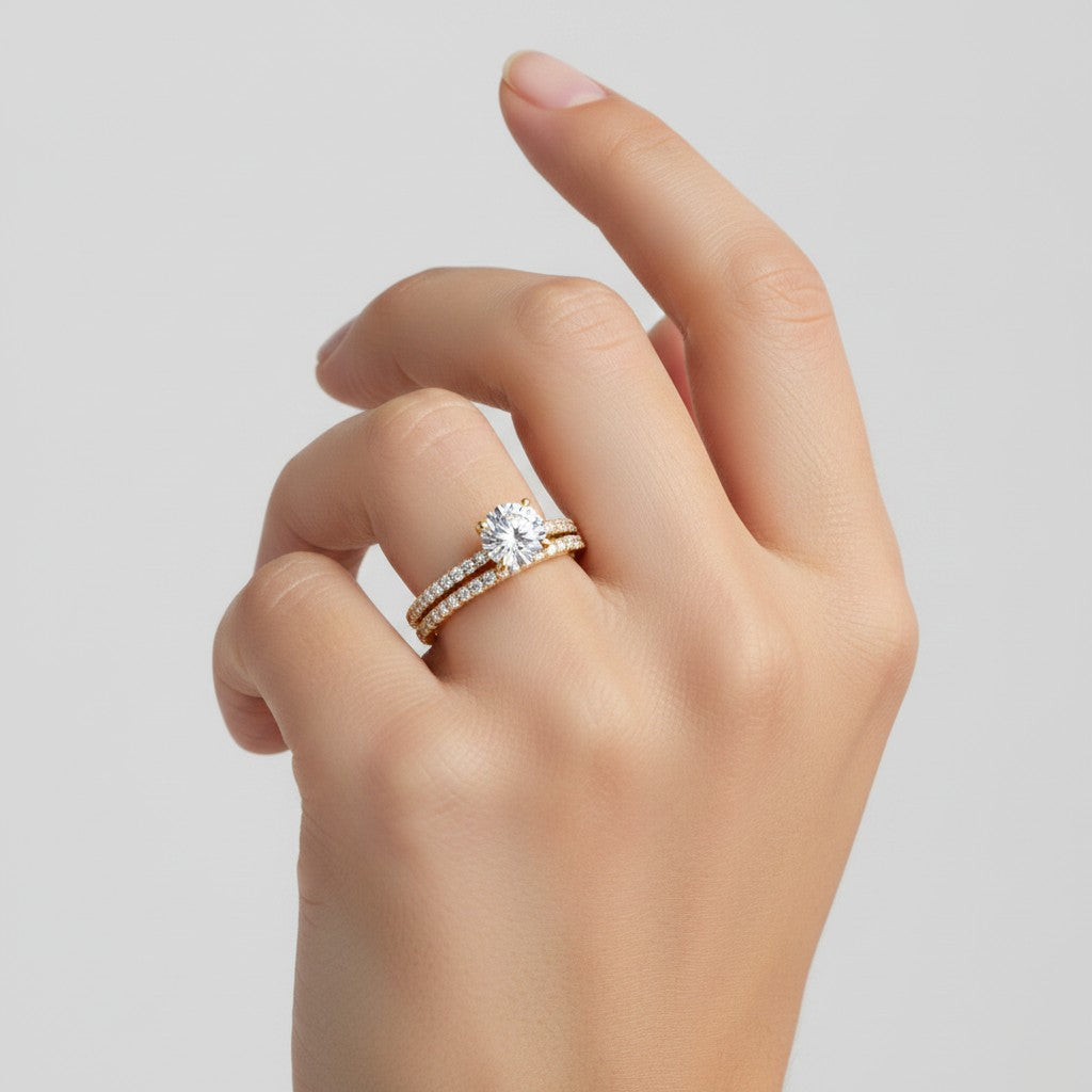 My Store 4 round diamond engagement ring and pavé wedding band set in 18k yellow gold worn on a woman's finger