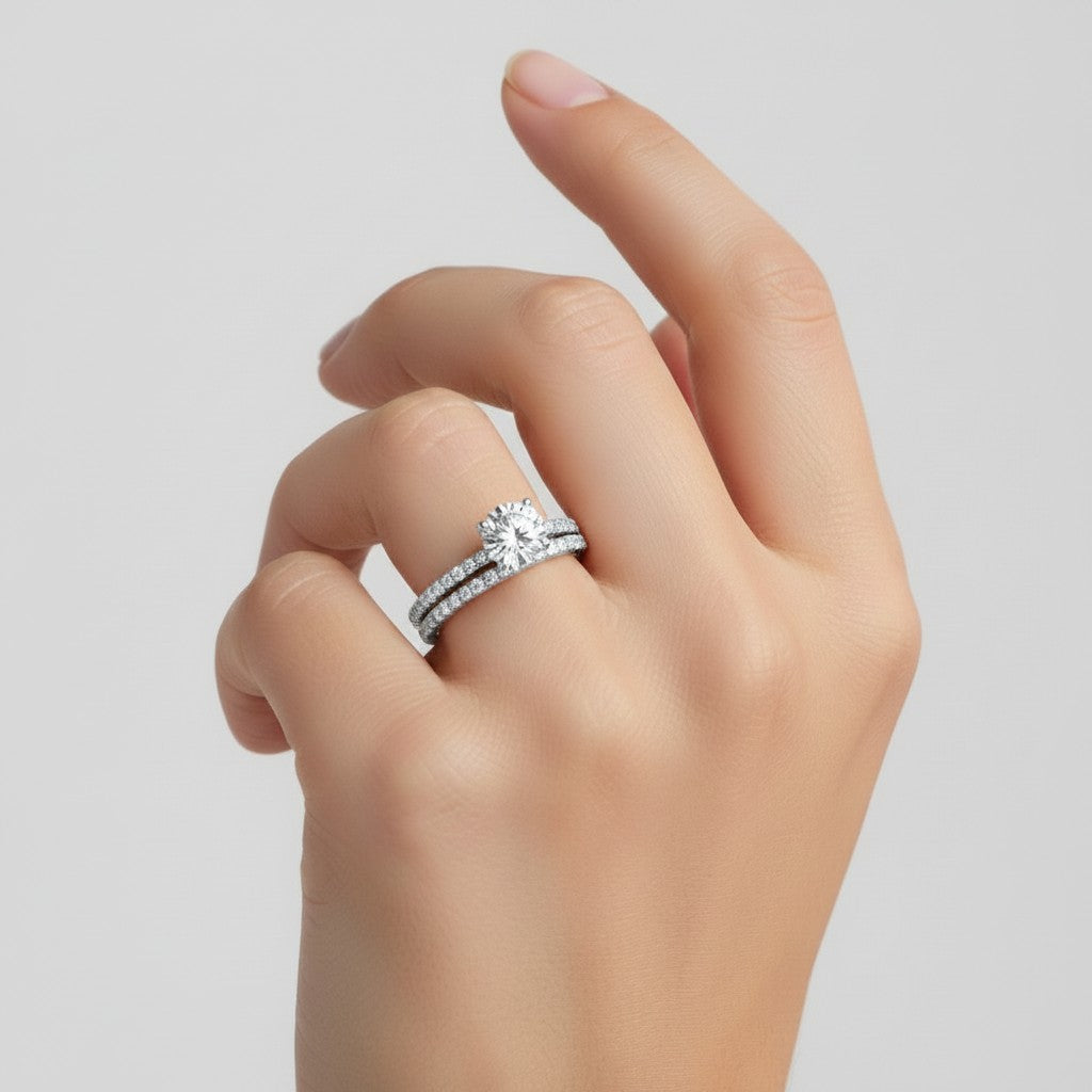 My Store 4 round diamond solitaire engagement ring and matching micro-pavé wedding band set worn on a finger.