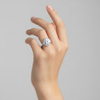My Store 4 round cut diamond engagement ring with a micro-pavé halo and diamond-set band on a woman's hand.