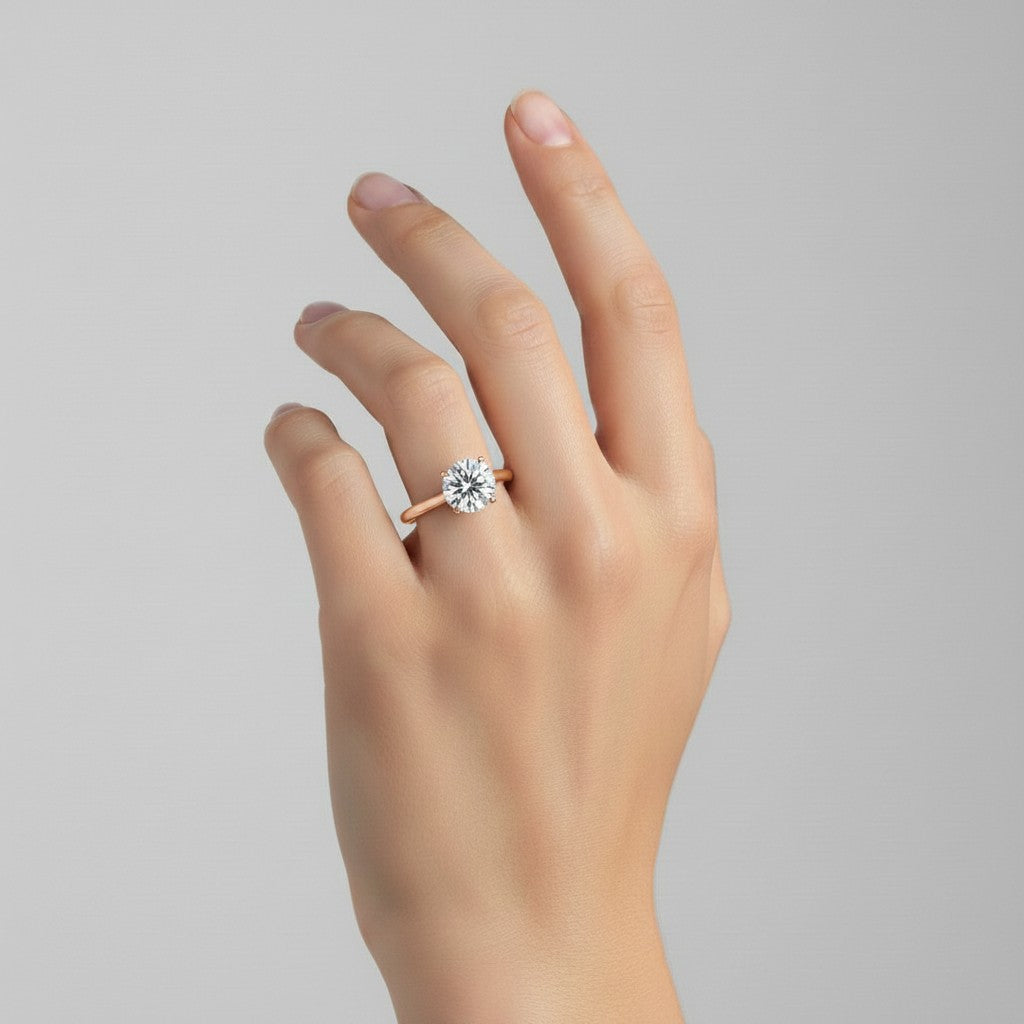 My Store 4 round cut solitaire engagement ring with a hidden halo on a hand, featuring a polished yellow gold band.