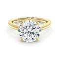 My Store 4 round cut solitaire engagement ring in yellow gold with a unique compass-prong setting on a white background.