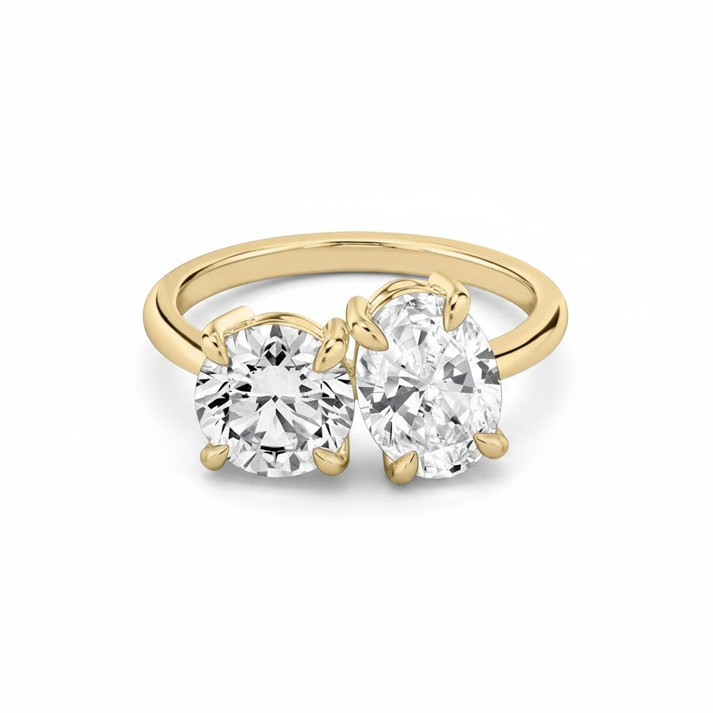My Store 4 Toi et Moi engagement ring featuring a round and oval diamond on a polished 18K yellow gold band.